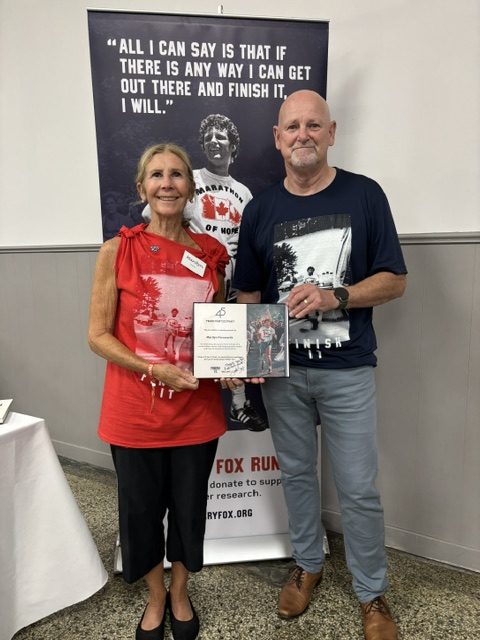 Marilyn Farnworth and another participant holding her 45-year Terry Fox Run recognition certificate.